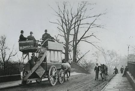 Circa 1900: A horse-drawn double-decker bus ambling across Monk Bridge