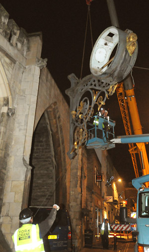 York Press: The clock is removed by workmen on a cherry picker