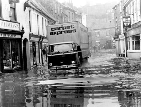 A determined lorry driver battles through the flood water in Walmgate