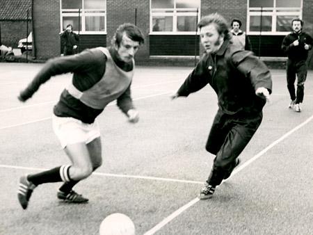 December 1975 - York City did some of their midweek training at York University. Martin Quinn, a 23-year-old central defender from Irish League club Cliftonville, who had a trial game with City Reserves, races across to cover Dennis Wann.