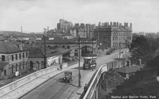 A car and a tram passing over the Queen Street Bridge in about 1920