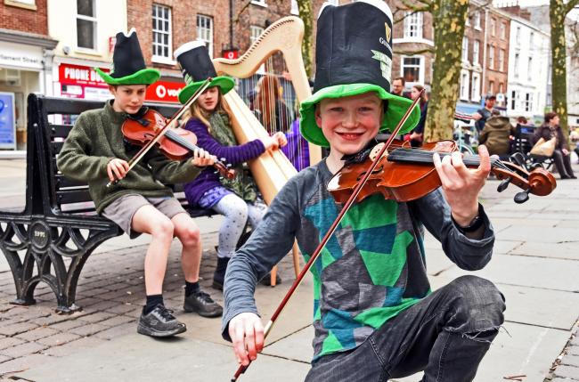 Members of the York based Folkestra group (right) Billy Ainsworth (Holgate),Hollis Lansford (left) from Acomb and Ivy Askew from Acomb entertain crowds celebrating St Patricks Day in Parliament St York.Pic Nigel Holland.
