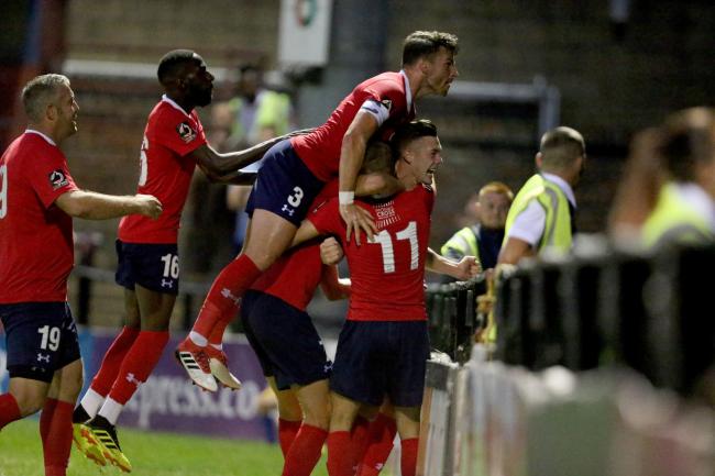 MAKING A NIGHT OF IT: York City’s players mob match-winner Wes York in front of a raucous David Longhurst Stand during the 1-0 victory over Stockport. That game could now be the last evening contest to take place at Bootham Crescent