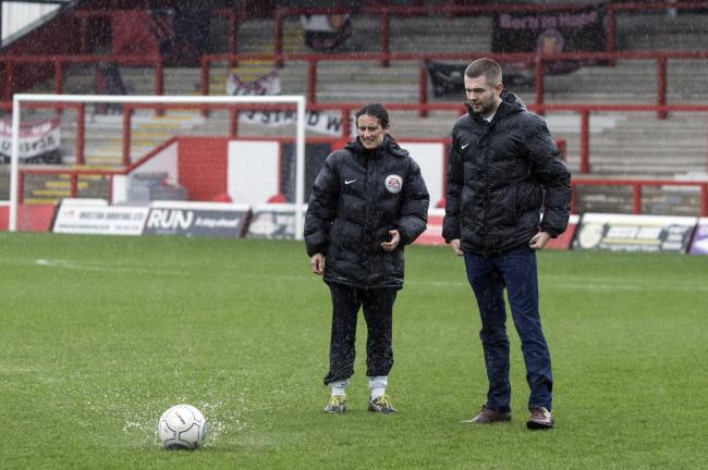 MAKING A SPLASH: Amy Fearn inspects FC United of Manchester's pitch before calling off York City's National League North match at Broadhurst Park. Picture: Ian Parker